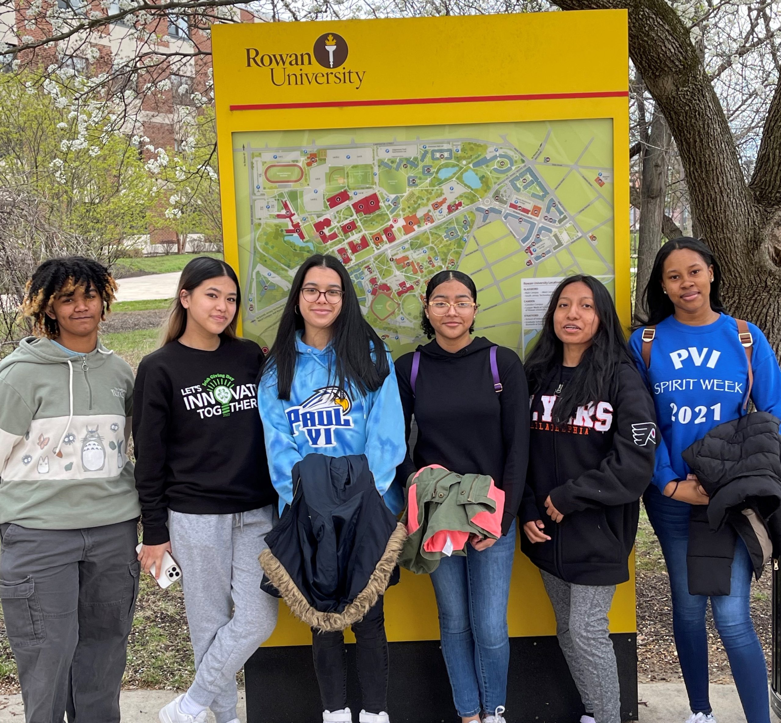 students standing in front of Rowan University map
