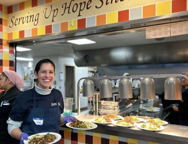 Volunteer serving food at Cathedral Kitchen